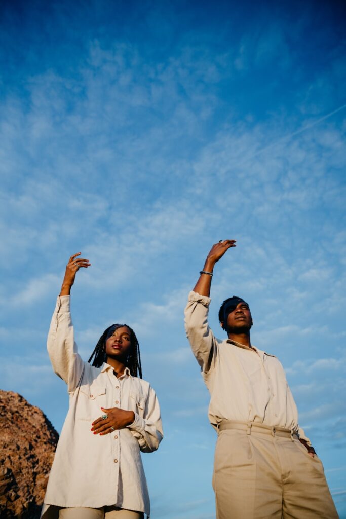 Two people dancing under a blue sky